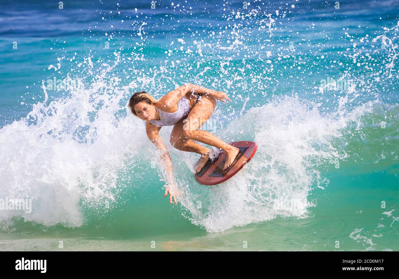 Eine junge Frau, die auf einer Welle vor Sandy Beach, Oahu, Oahu, Hawaii, Vereinigte Staaten von Amerika abrutscht Stockfoto
