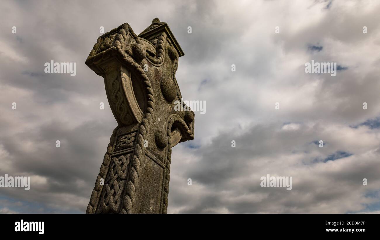 Keltische Kreuz Grabstein, bewölkt dramatischen Himmel Hintergrund Stockfoto