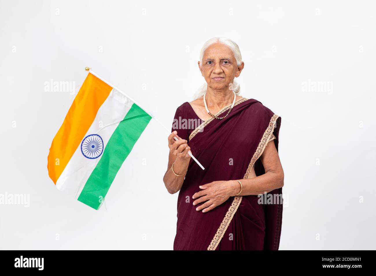Ältere indische Dame, die die indische Nationalflagge hält. Ältere Frau, die die indische Trikolore hält Stockfoto