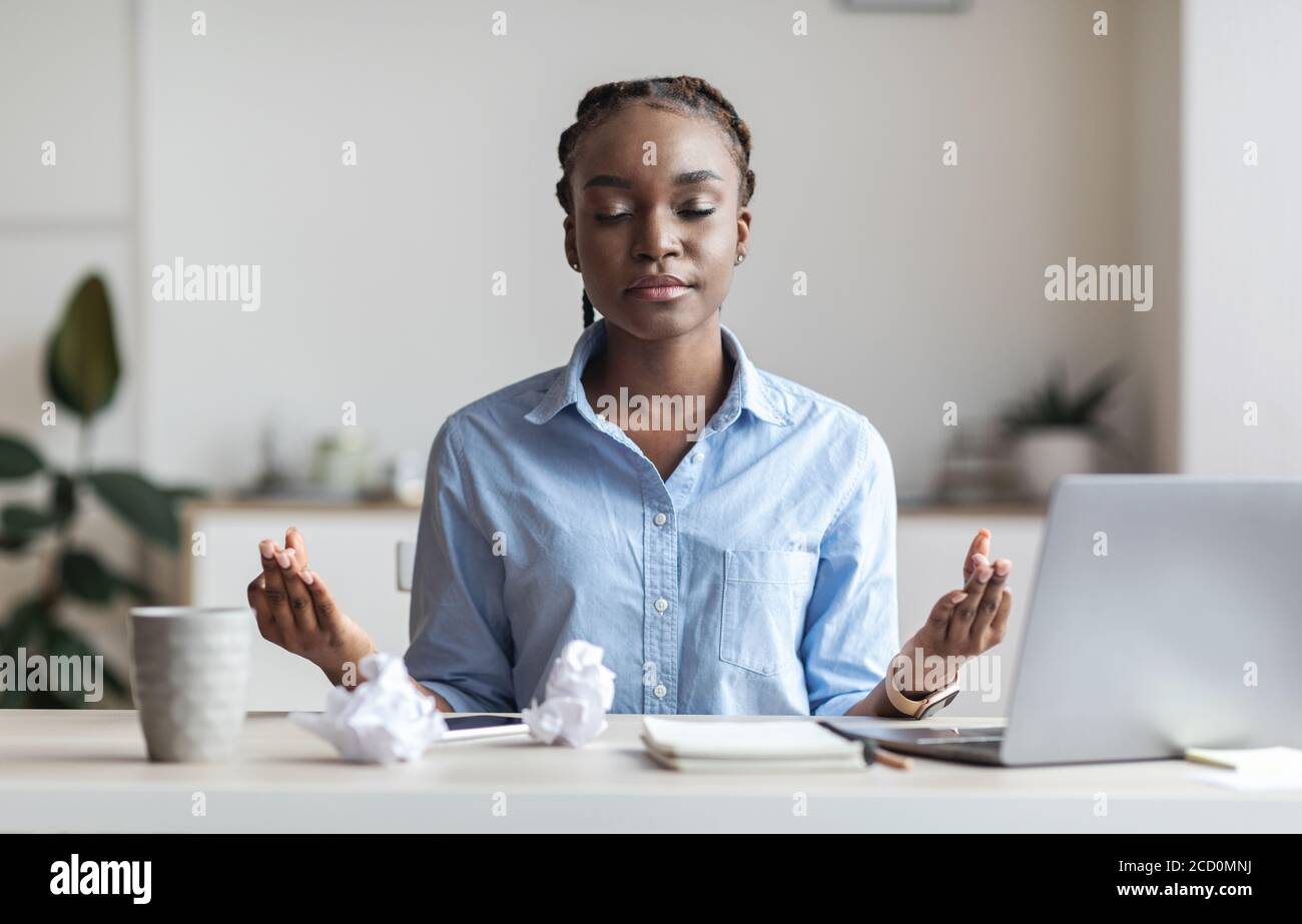 Umgang Mit Stress Bei Der Arbeit. Junge Afrikanische Geschäftsfrau Meditiert Im Büro Stockfoto