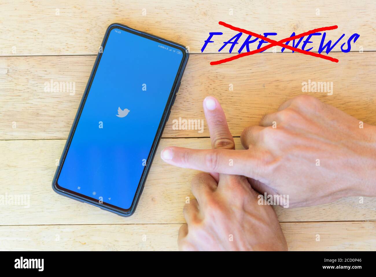 Bangkok, Thailand - 25 August, 2020 : das Logo von twitter wird geladen mit Finger Kreuz Zeichen für Anti Fake News Stockfoto