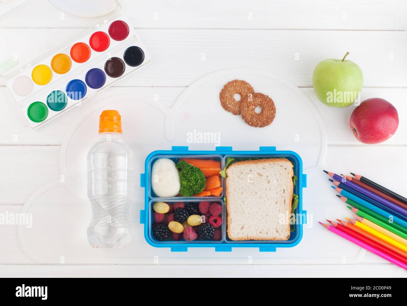 Offene Lunchbox mit Sandwich, Gemüse, Ei, frischen Beeren in der Nähe Wasserflasche auf dem weißen Holzhintergrund. Draufsicht, flach liegend. Stockfoto