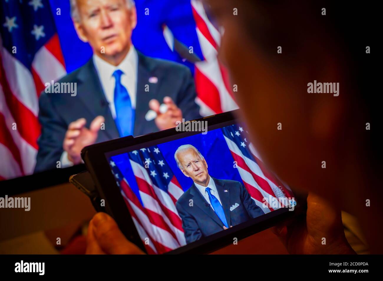 Ein Wähler beobachtet Senator und demokratischer Präsidentschaftskandidat Joe Biden geben seine Dankesrede auf der virtuellen Demokratischen Nationalversammlung am Donnerstag, 20. August 2020. (© Richard B. Levine) Stockfoto