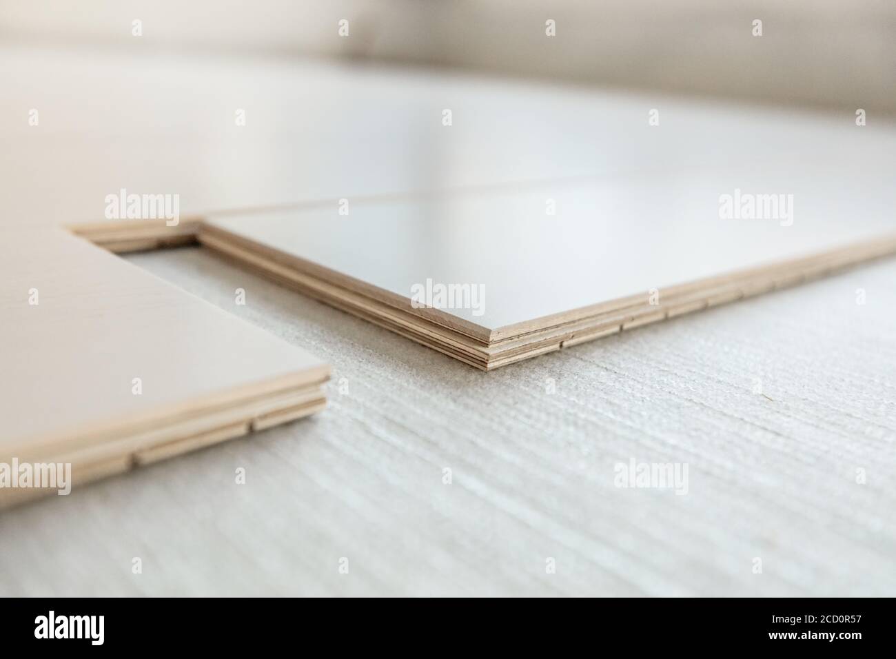 Technische Holzbodeninstallation mit Unterflurmembran in der Wohnung. Ahorn Hartholz Bodenbeläge Planken Nahaufnahme zeigt Composite Sperrholz Schichten Stockfoto