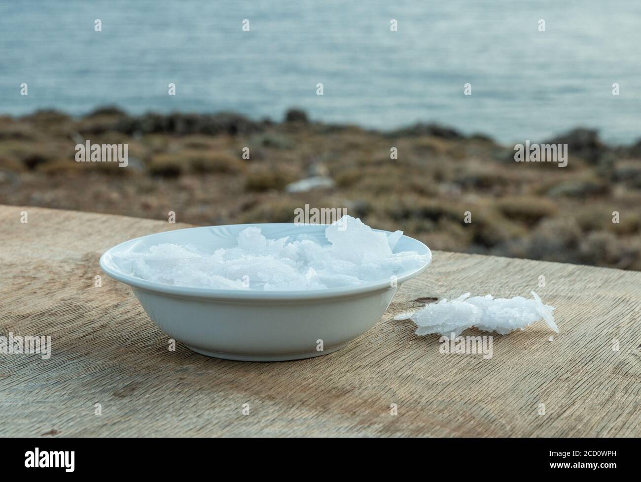 Blume griechischer Meersalzkristalle, Südkreta. Natürliche traditionelle Fleur de Sel von Kreta. Meersalzflocken auf Holzbakkboden. Stockfoto