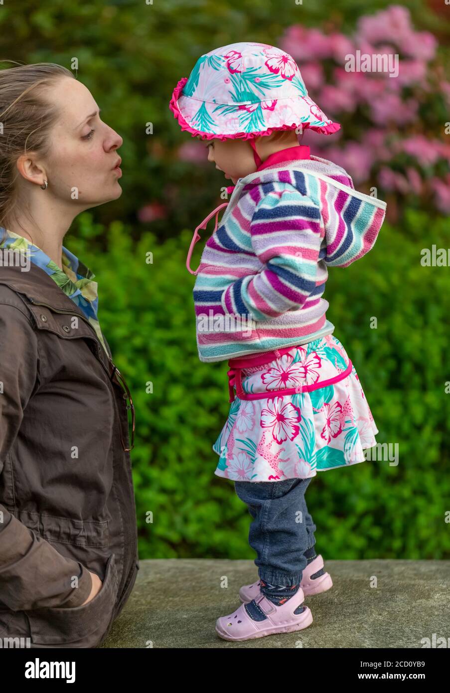 Mutter steht neben Tochter und spricht von Angesicht zu Angesicht in einem Park; Surrey, British Columbia, Kanada Stockfoto