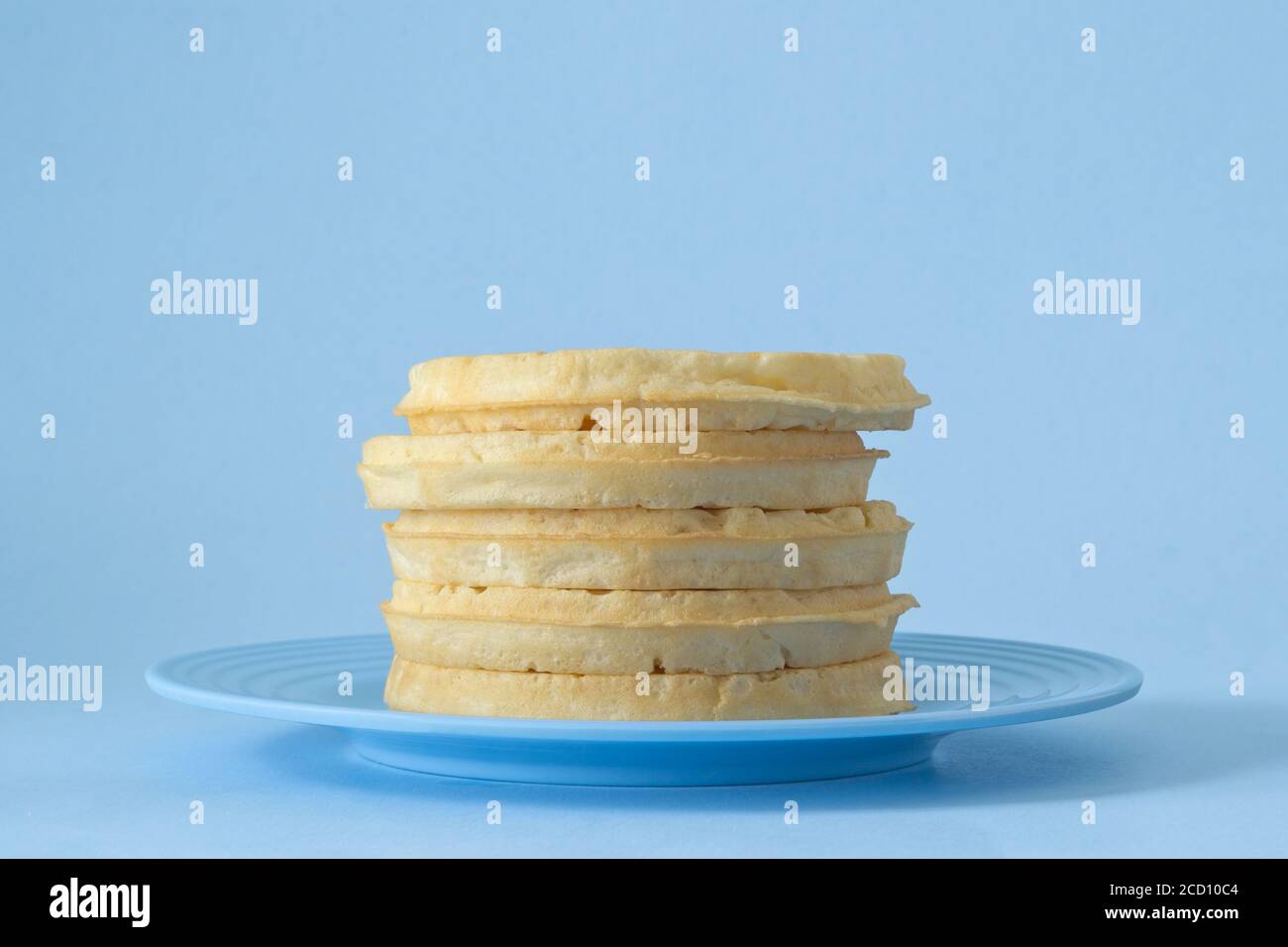 Runde Waffeln zum Frühstück auf blauem Teller gestapelt Stockfoto