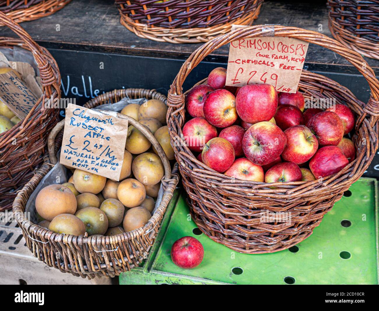 Farm Bio Äpfel 'CHEGWORTH RUSSET & 'CRIMSON CHIPS' in Weide Körbe zum Verkauf auf Borough Market mit einfachen Rustikale Etiketten "chemikalienfrei" Southwark London UK Stockfoto