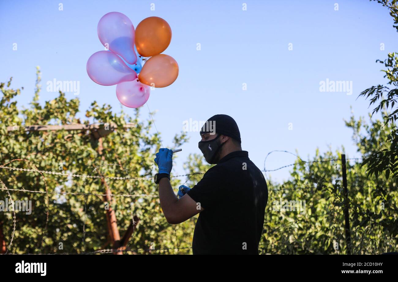 Gazastreifen, Dschabalia, Gaza. August 2020. Maskierte Palästinenser, die Luftballons freilassen, bringen sie mit Brandvorrichtungen in Israel in der Nähe des Flüchtlingslagers Jabalya entlang der Grenze zwischen Israel und Gaza an. Kredit: Nidal Alwaheidi/SOPA Images/ZUMA Wire/Alamy Live Nachrichten Stockfoto