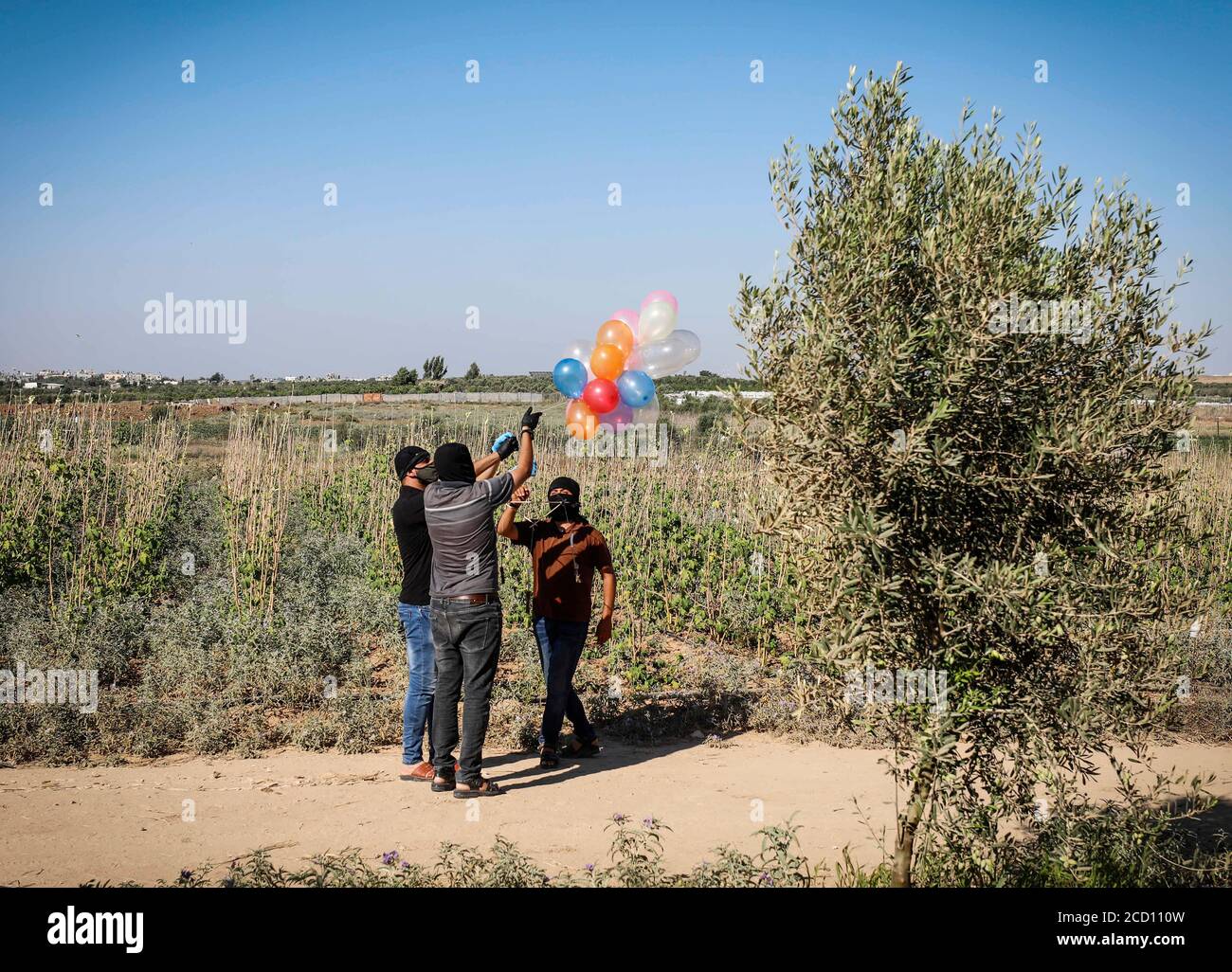 Gazastreifen, Dschabalia, Gaza. August 2020. Maskierte Palästinenser entließen Luftballons, die mit Brandvorrichtungen in Israel in der Nähe des Flüchtlingslagers Jabalya entlang der Grenze zwischen Israel und Gaza befestigt waren. Kredit: Nidal Alwaheidi/SOPA Images/ZUMA Wire/Alamy Live Nachrichten Stockfoto