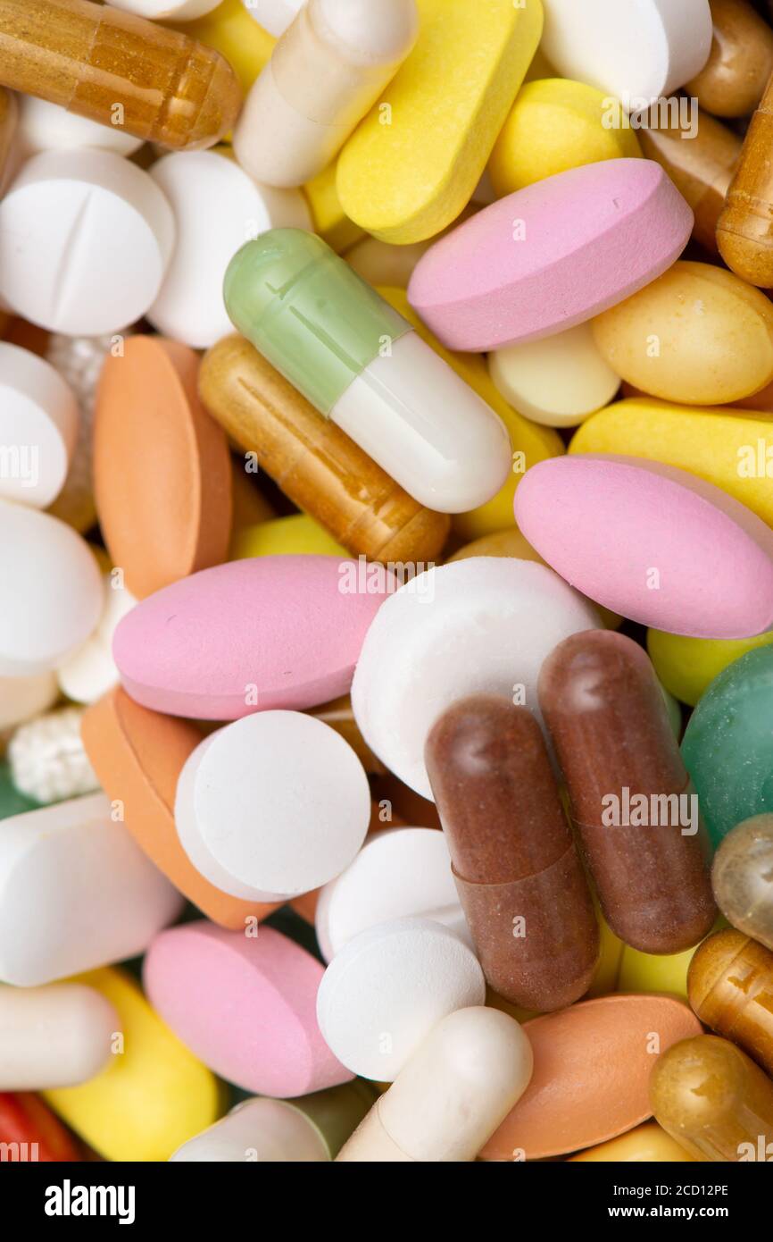 Medikamente (Tabletten, Kapseln, Pillen) von verschiedenen Arten, Größen und Farben, in großen Mengen angehäuft. Nahaufnahme. Konzepte von Krankheit, Krankheit, Behandlung und mir Stockfoto