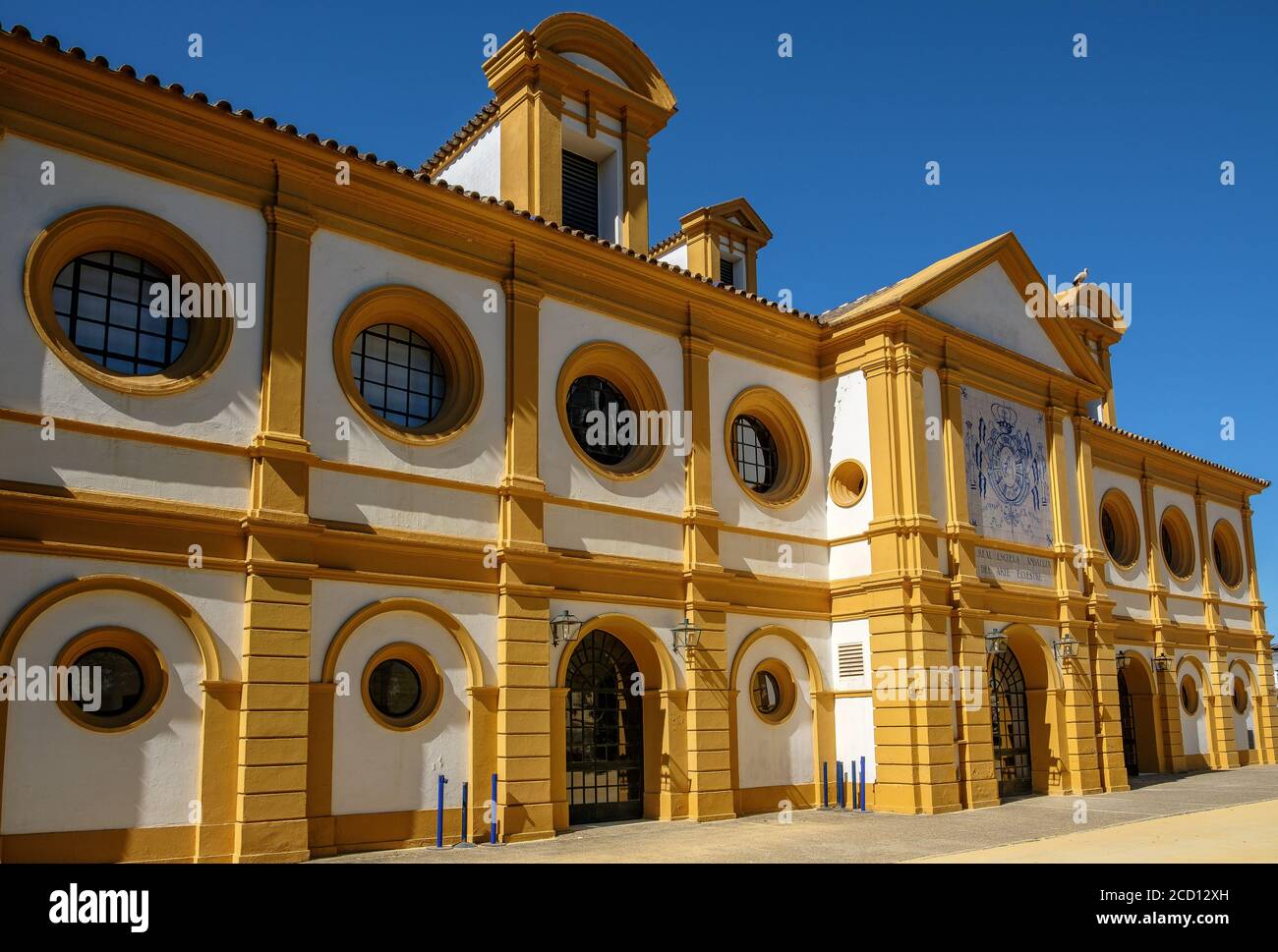 Schönes gelb-weißes Gebäude an der Königlichen Andalusischen Schule Von Reitsportanlagen in Jerez de la Frontera Stockfoto