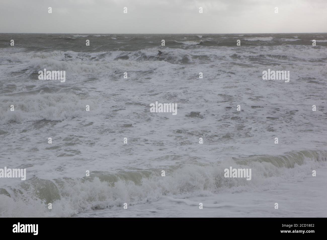 UK Wetter, 25. August 2020: Ein eineinziger Surfer geht in East Wittering gegen riesige Wellen, während der Sturm Francis die Sussex-Küste passiert. Anna Watson/Alamy Live News Stockfoto
