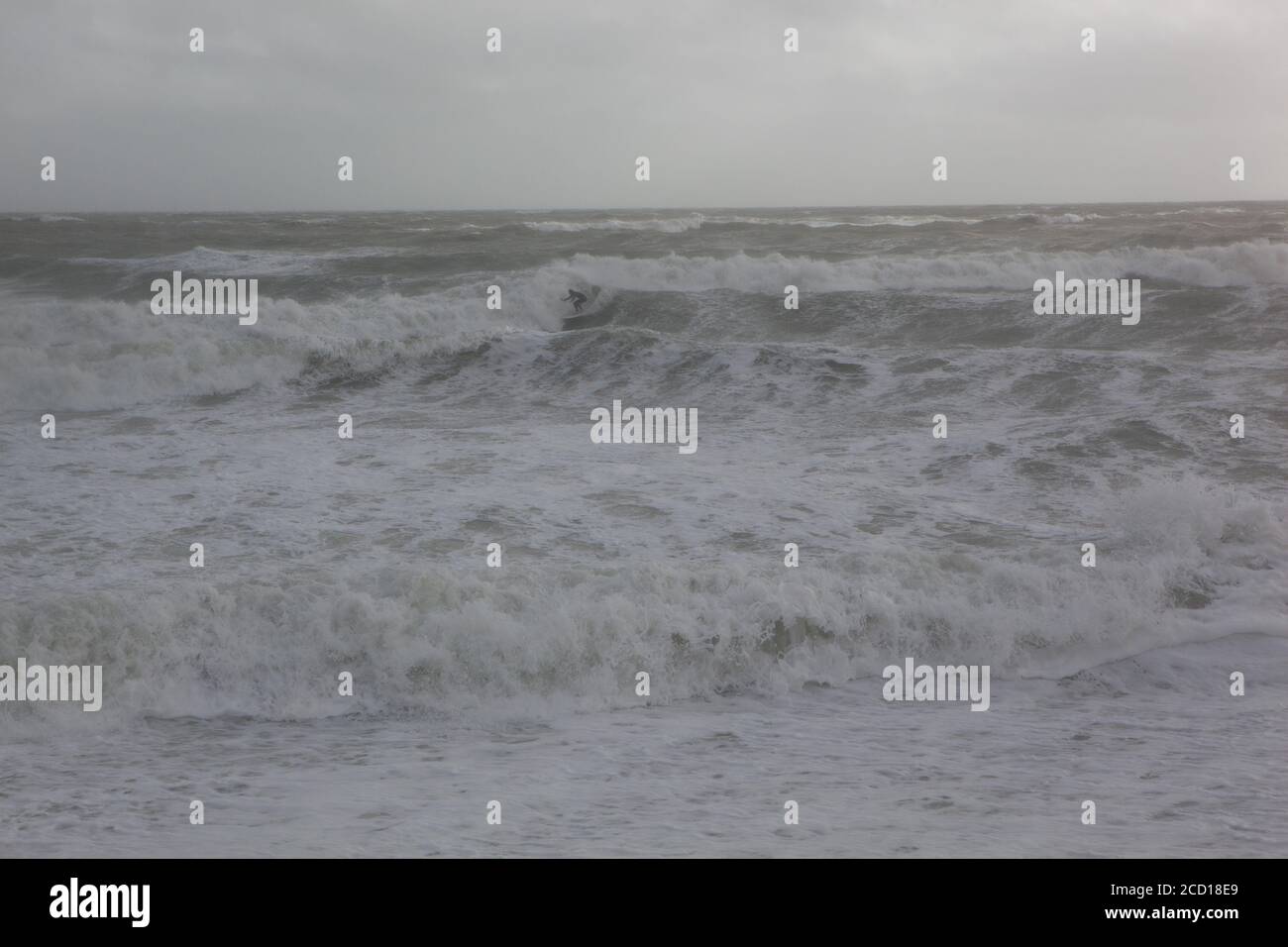 UK Wetter, 25. August 2020: Ein eineinziger Surfer geht in East Wittering gegen riesige Wellen, während der Sturm Francis die Sussex-Küste passiert. Anna Watson/Alamy Live News Stockfoto
