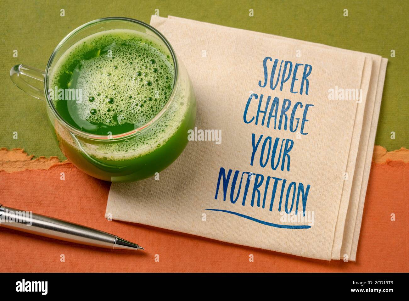Super laden Sie Ihre Ernährung inspirierende Note - Handschrift auf einer Serviette mit einem Glas frischen, grünen Gemüsesaft, gesunde Ernährung und Lifestyle Co Stockfoto