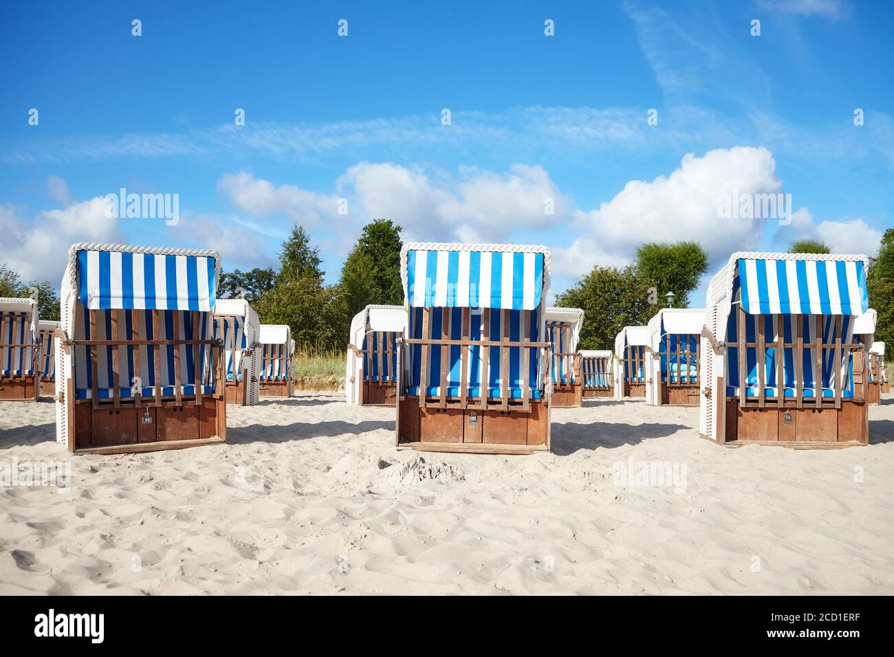 Leere Strandkörbe auf Sand. Stockfoto