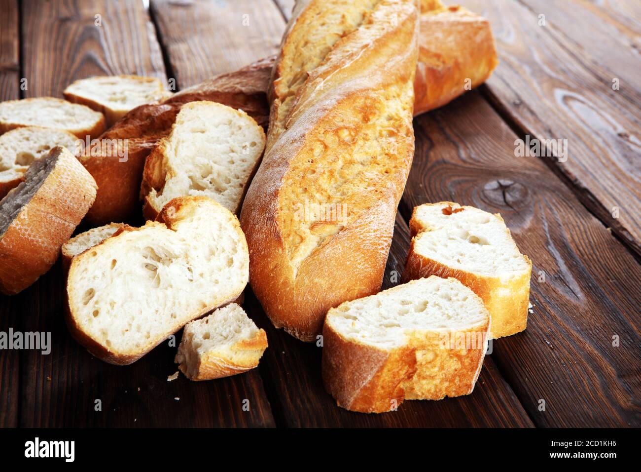 Baguette gebackenes Brot und geschnittenes Baguette auf Holzhintergrund Stockfoto