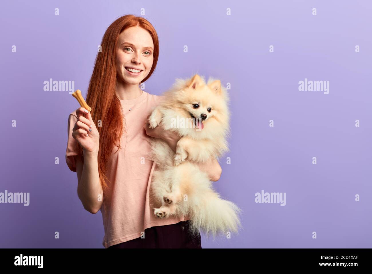 Positive rothaarige Mädchen mit Spaß mit ihrem Hund, Nahaufnahme Porträt,  isoliert blauen Hintergrund, Studio erschossen Stockfotografie - Alamy