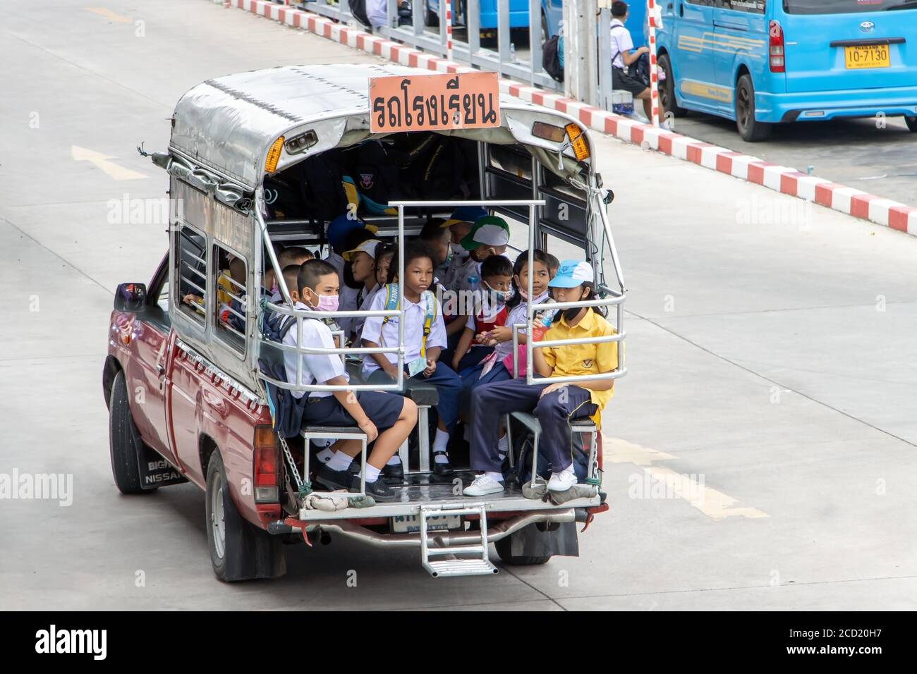 SAMUT PRAKAN, THAILAND, 03 2020. JULI, die thailändischen Kinder in Schuluniformen fahren von einer Schule in einem traditionellen Abholbus. Stockfoto