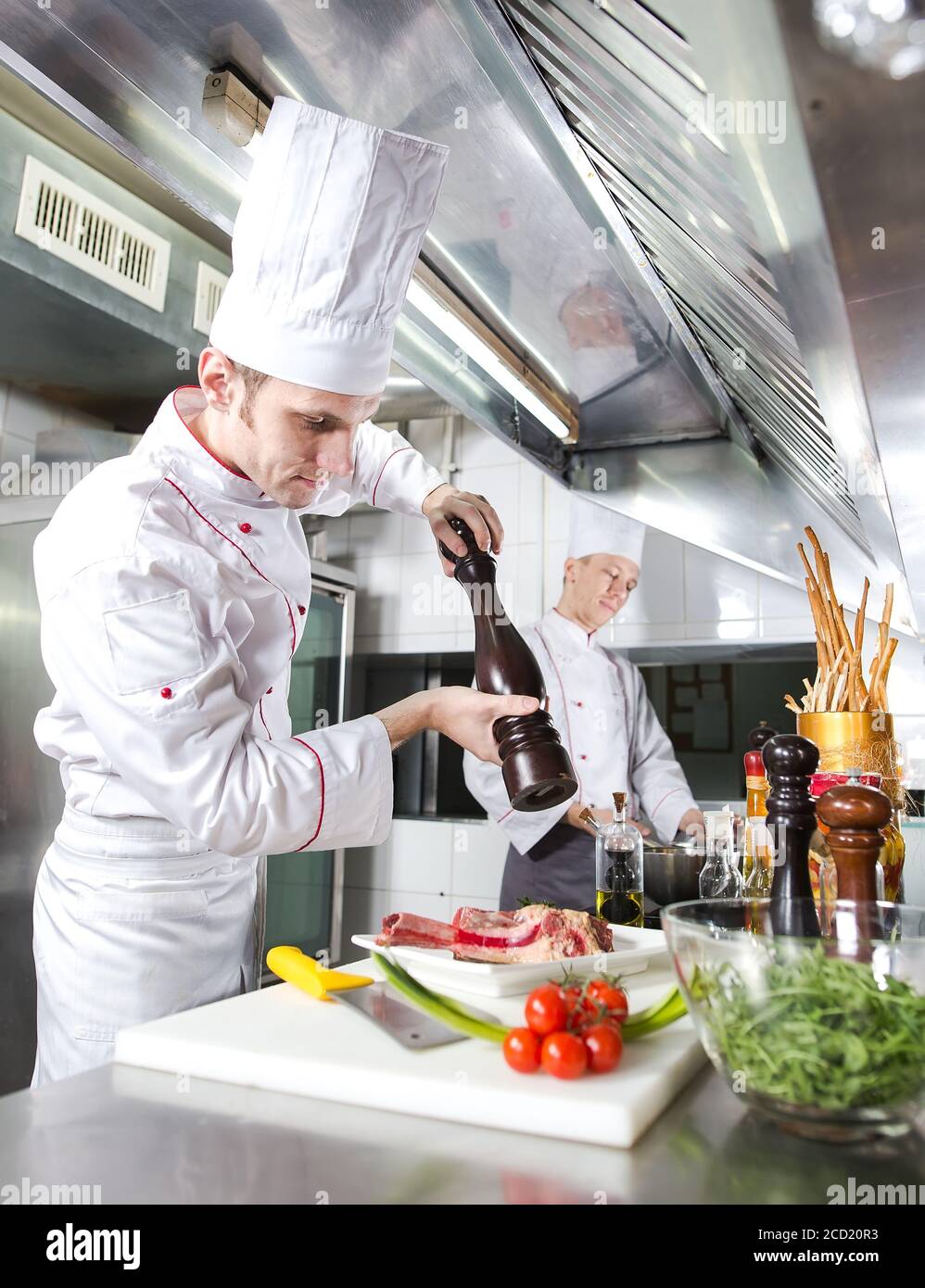 Der Küchenchef bereitet ein Gericht in der Küche des Restaurant Stockfoto