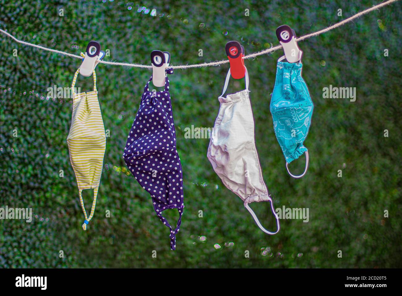 Trocknen außerhalb wiederverwendbare Familie Gesichtsmasken, hängen an einer Wäscheleine Nylon Seil mit Wäscheklammern. Stockfoto