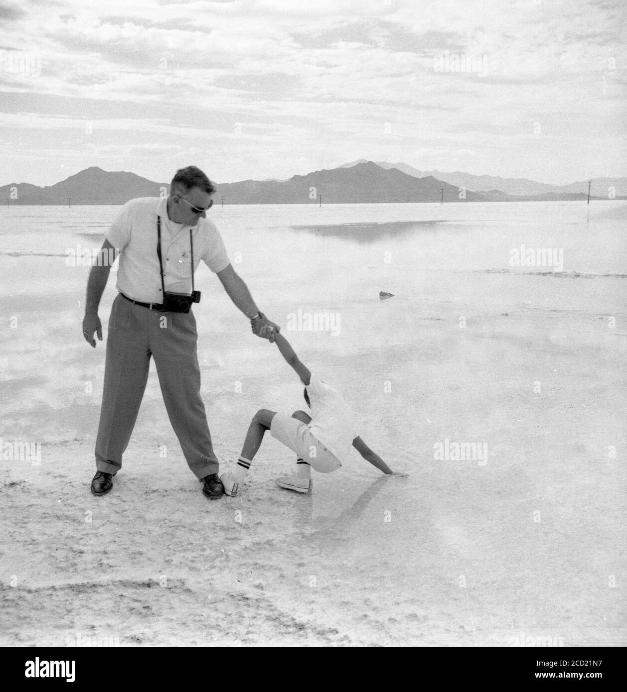 Vater hält Sohn, während er Salzwasser auf den Bonneville Salt Flats, Utah, USA erforscht Stockfoto