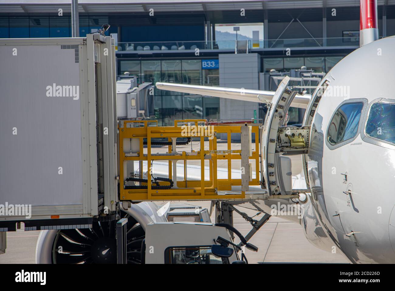Versorgung des Flugzeugs mit Lebensmitteln aus einem Container, der angehoben wird und mit der offenen Tür eines Flugzeugs verbunden ist. Stockfoto