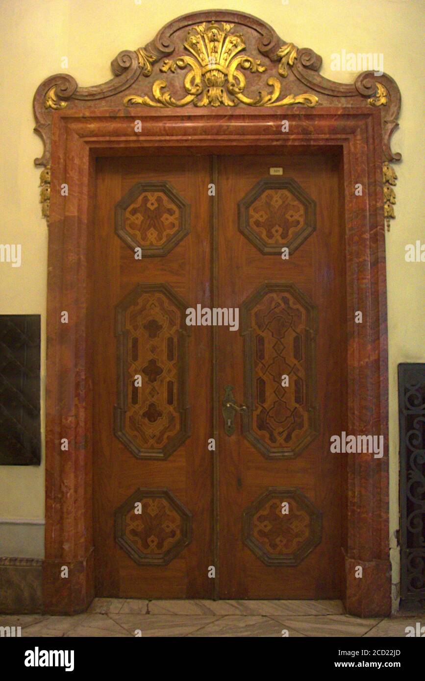 Eine beeindruckende schwere Holztür mit braunem Marmorrahmen Stockfoto