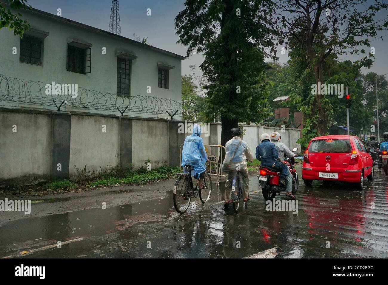 Kolkata, Westbengalen, Indien - 25. Juli 2020 : Radfahrer auf regen durchnässt Kolkata Straße, Monsunbild von Kolkata. Stockfoto