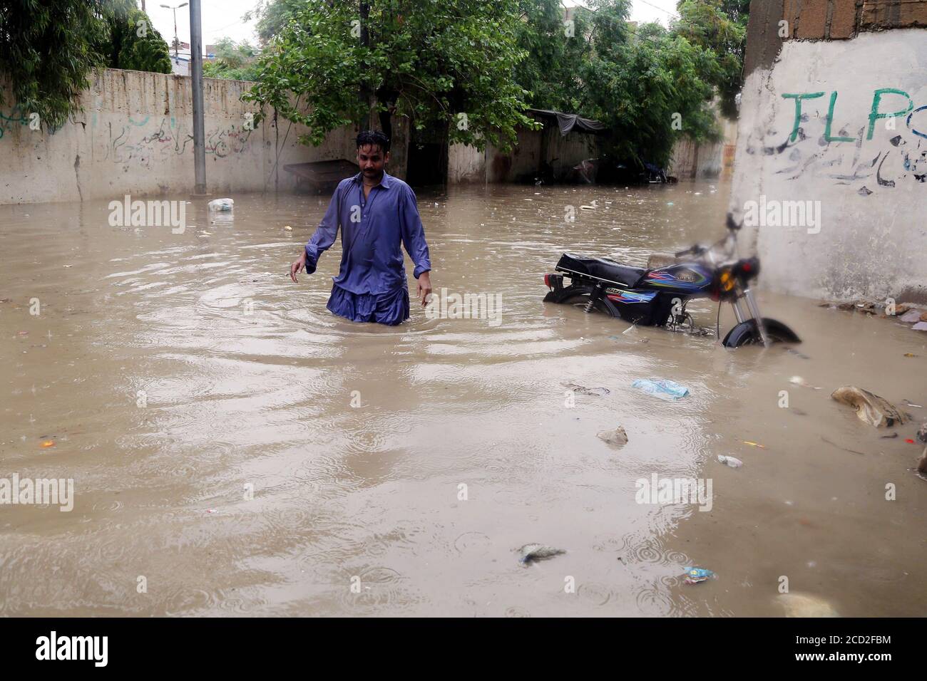 (200826) -- KARACHI, 26. August 2020 (Xinhua) -- EIN Mann wat am 25. August 2020 in der südpakistanischen Stadt Karachi nach heftigem Monsunregen durch Flutwasser. Heftige Monsunregen haben einen 36-jährigen Regenguss-Rekord im Monat August in der Hauptstadt Karachi der südlichen Provinz Sindh in Pakistan gebrochen, hat Pakistan Meteorological Department (PMD) gesagt. Die starken Regenfälle haben in mehreren Teilen der Stadt verheerende Auswirkungen auf Überschwemmungen, eintauchende Straßen, Straßen, Fahrzeuge und tief liegende Gebiete. Regenunfälle, einschließlich Stromschlag und Dacheinsturz, behaupteten ebenfalls li Stockfoto