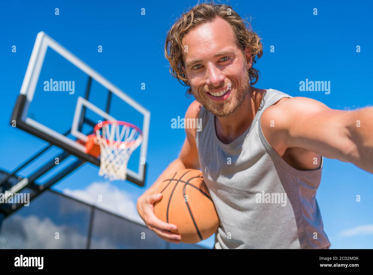 Basketball-Spieler Mann macht Spaß Selfie Foto am Court Netz mit Basketball. Stockfoto