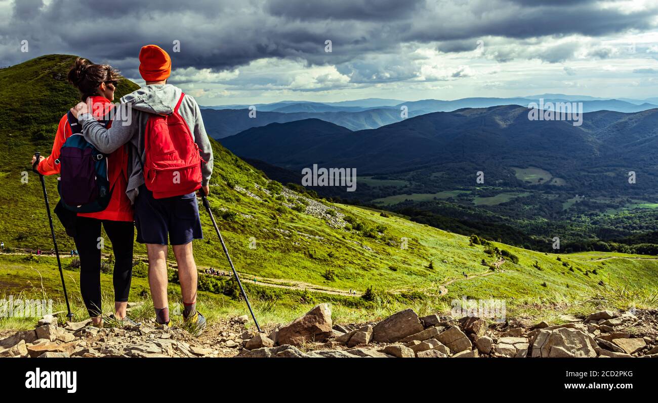 Ein paar Wanderer bleiben auf der Spitze des Hügels in den Bergen. Stockfoto