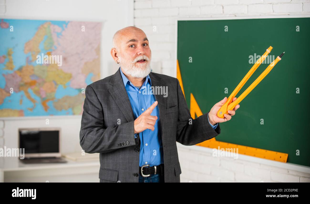 Älterer Mann Lehrer verwenden Kompass Werkzeug. Bärtiger Lehrer Mann zeichnen mit Kompass auf Tafel. Zurück zur Schule. Mathematische Grafik-Tools Konzept. Auf dem Weg zum Wissen. Studieren Sie Mathematik, um gute Ergebnisse zu erzielen. Stockfoto