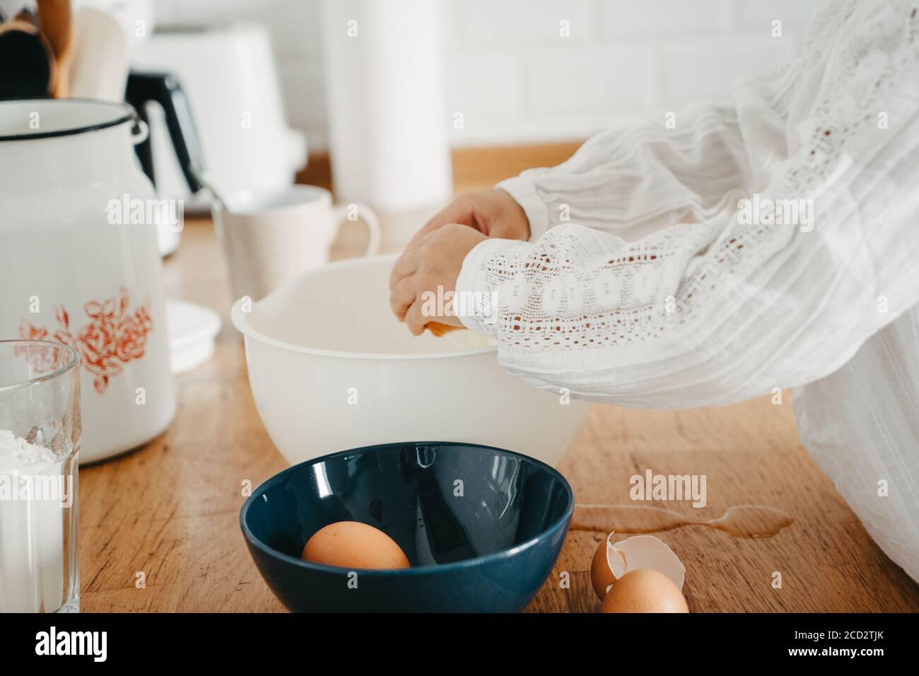Kleines Mädchen bereitet Teig für Pfannkuchen in der Küche. Konzept der Lebensmittelzubereitung, selektiver Fokus, Nahaufnahme von Details. Freizeit Lifestyle Foto ser Stockfoto