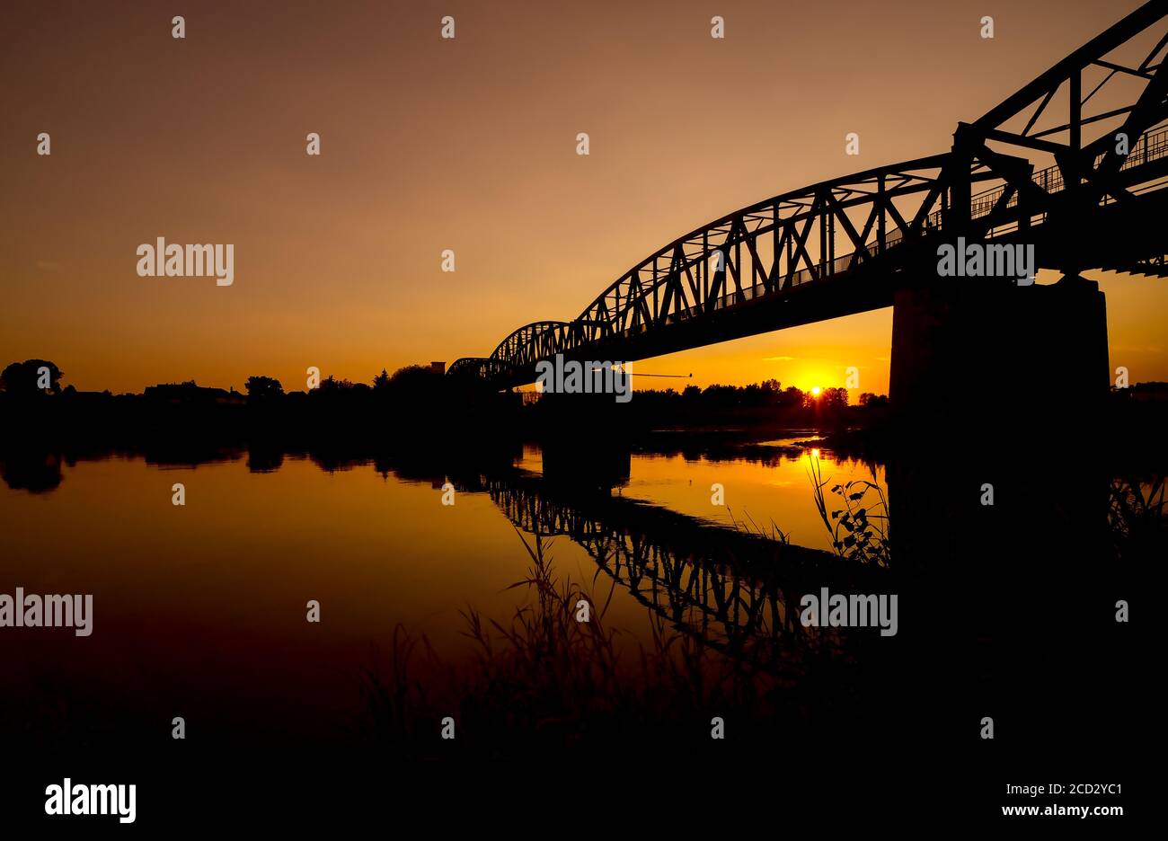 Die Spiegelung der alten Brücke auf dem Fluss, die Silhouette Der alten Brücke bei Sonnenaufgang oder Sonnenuntergang in der Auf dem Land Stockfoto
