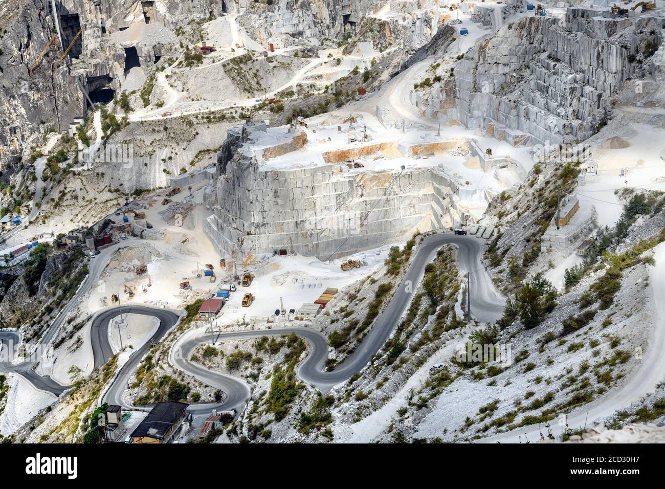 Panoramablick auf Carrara Marmorsteinbrüche in einem steilen Berg Tal mit Tagebau und einer kurvenreichen Straße Toskana Italien Stockfoto
