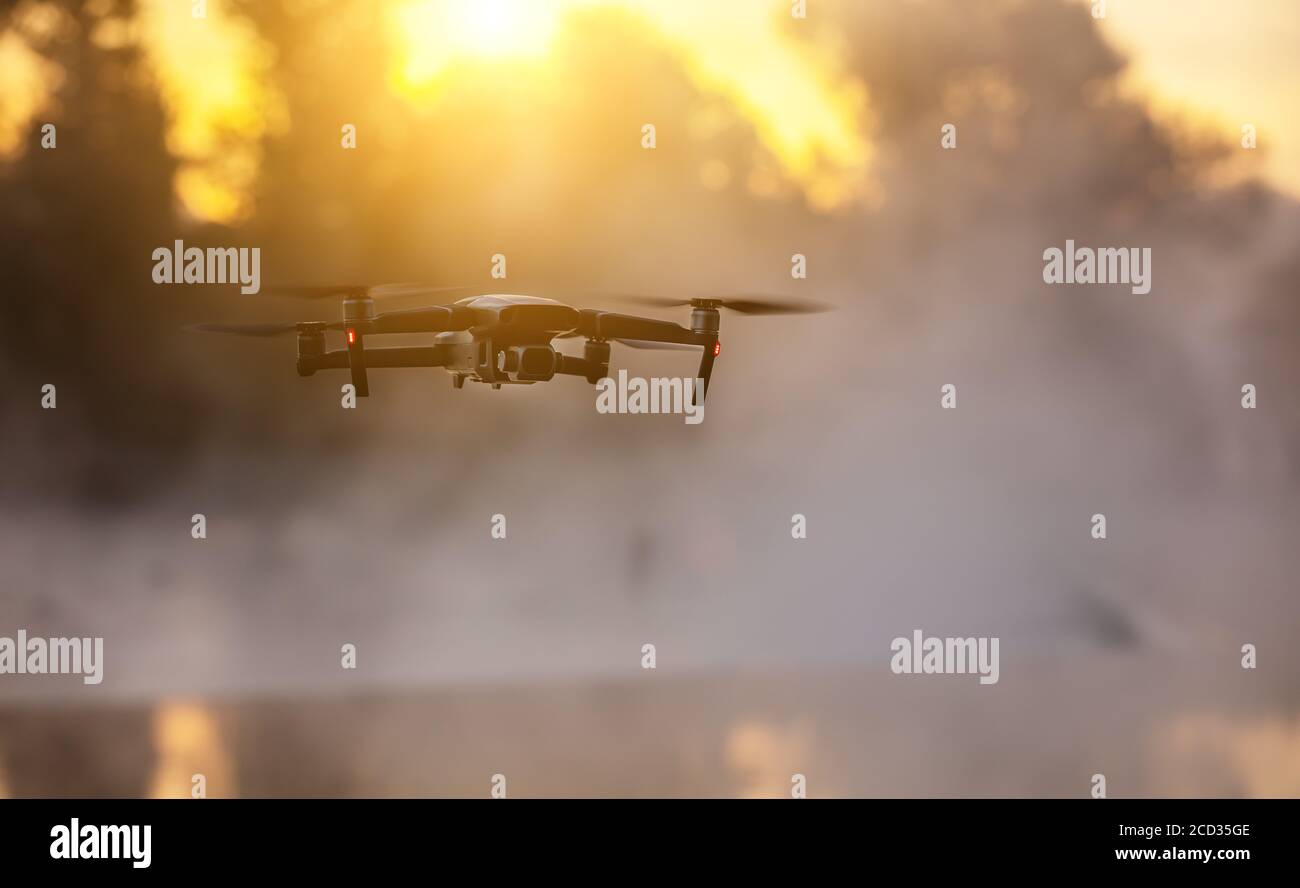 Drohne Kopter mit Digitalkamera, verwischen Fluss auf Hintergrund. Moderne Technik, UAV-Konzept. Wunderschöne nicht urbane Landschaft im Freien. Stockfoto