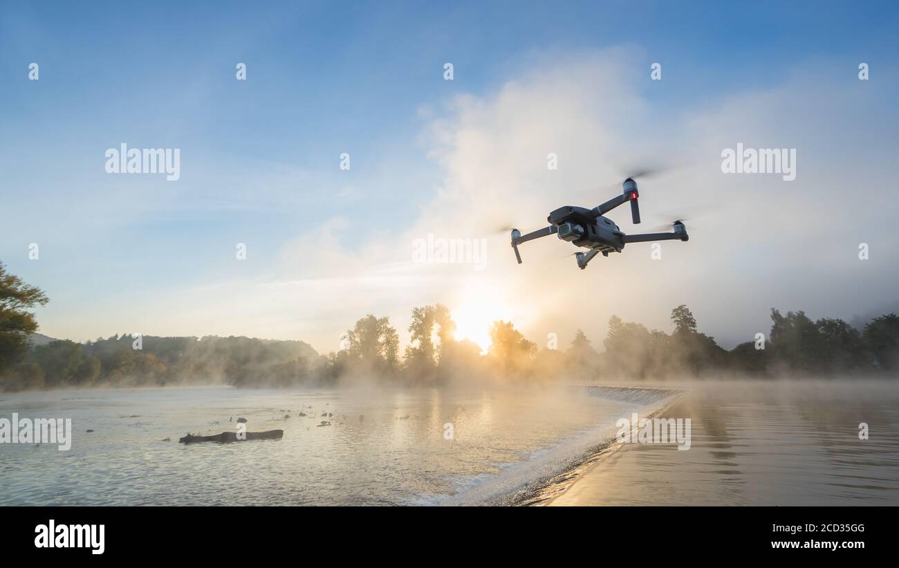 Drohne Kopter mit Digitalkamera, verwischen Fluss auf Hintergrund. Moderne Technik, UAV-Konzept. Wunderschöne nicht urbane Landschaft im Freien. Stockfoto