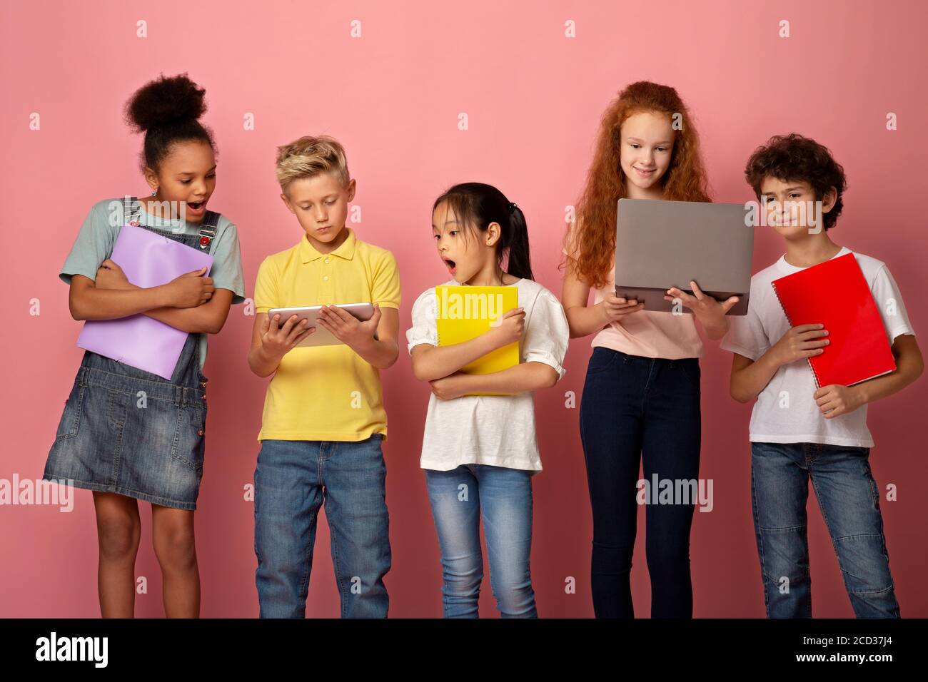 Porträt von multiethnischen Schülern mit Notebooks mit Tablet und Laptop Auf rosa Hintergrund zu studieren Stockfoto
