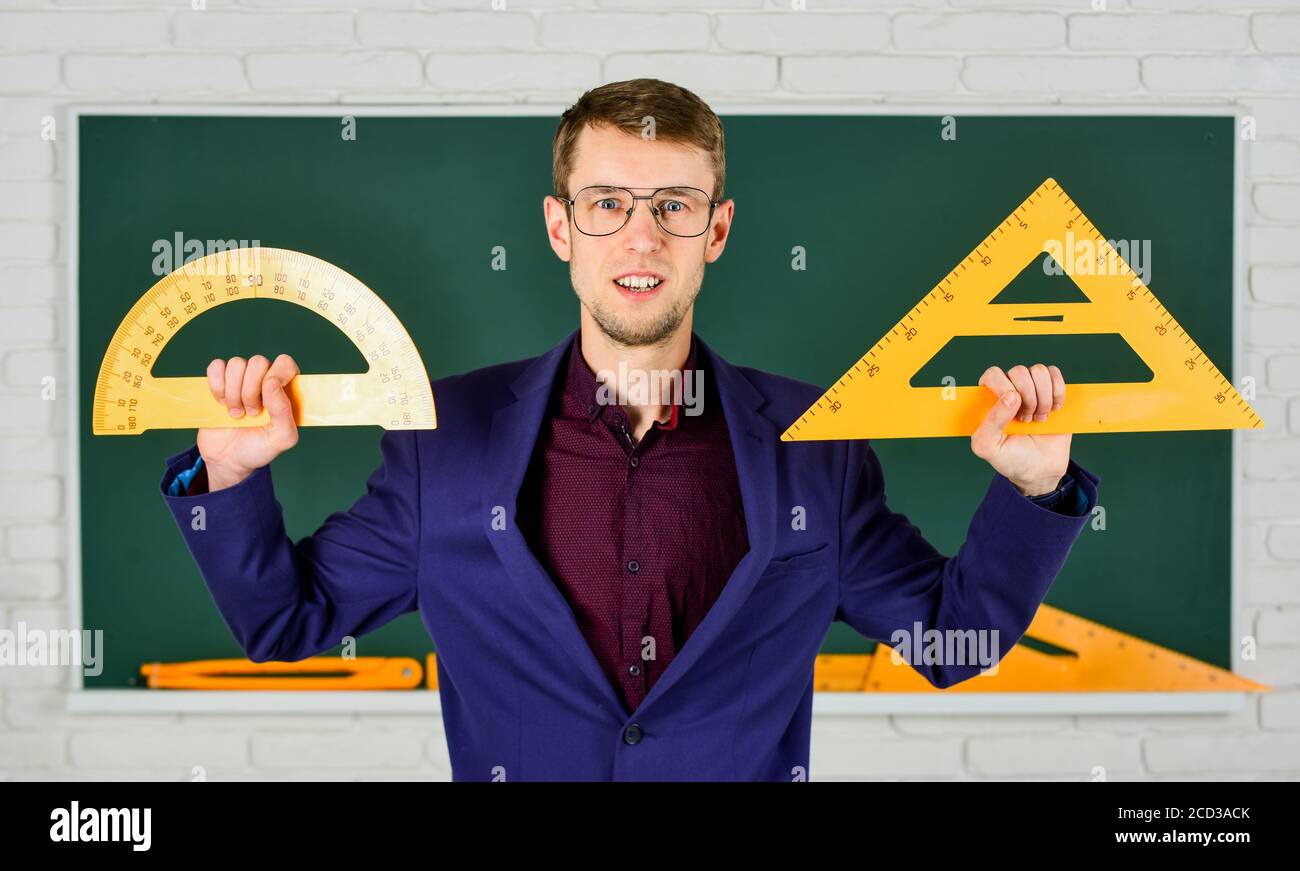 MINT Schule Disziplinen. Mathematik und Menschen Konzept. Mann an der Tafel. Zurück zur Schule. Geometrie Lieblingsthema. Männliche Lehrer halten Winkelmesser und Dreieck. Bildung in der Schule. Stockfoto