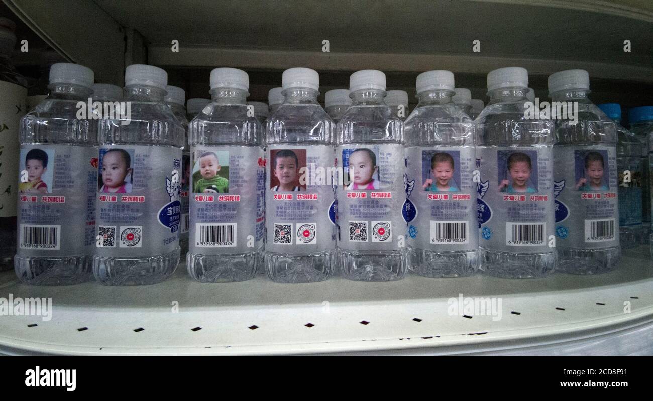 Arrays von Flaschen Sodawasser, auf deren Oberfläche Informationen über vermisste Kinder angezeigt werden, die dazu beitragen, diese Kinder für ihre p zu finden Stockfoto