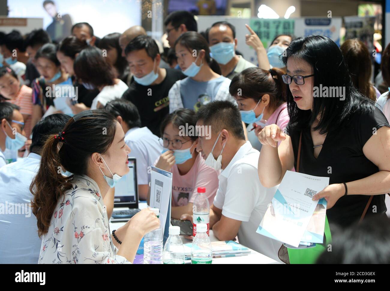 Leute erkundigen sich auf Hochschulen durch einen Hochschulberatungschalter an der Hochschulanwendung Beratungsmesse und Hochschulausstellung in Xi'an Stadt, Nordwesten Chi Stockfoto