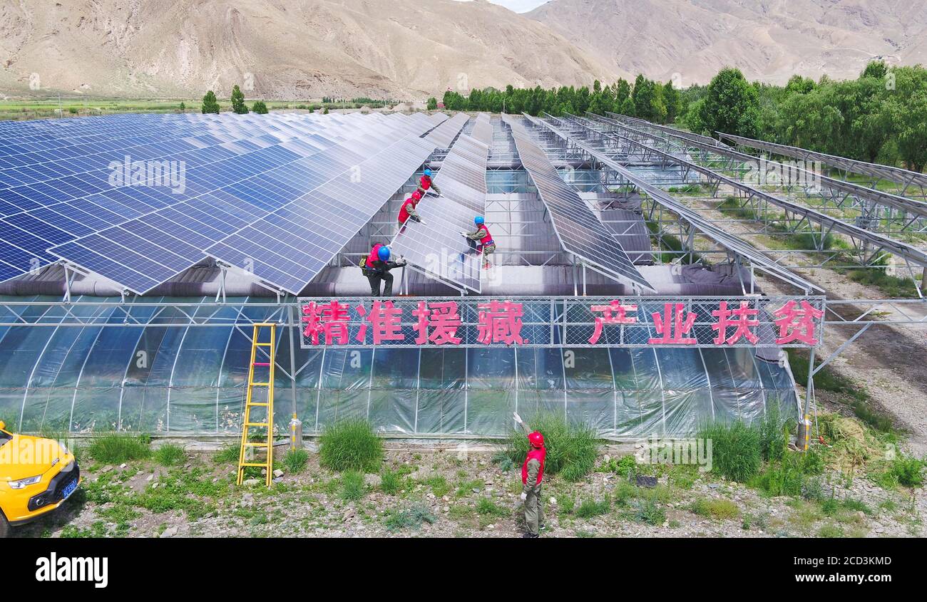 Wartungsarbeiter untersuchen die Photovoltaikanlagen, die im Rahmen der Armutsbekämpfung im Qonggyai County, im südwestlichen Tibet Chinas, gebaut wurden Stockfoto