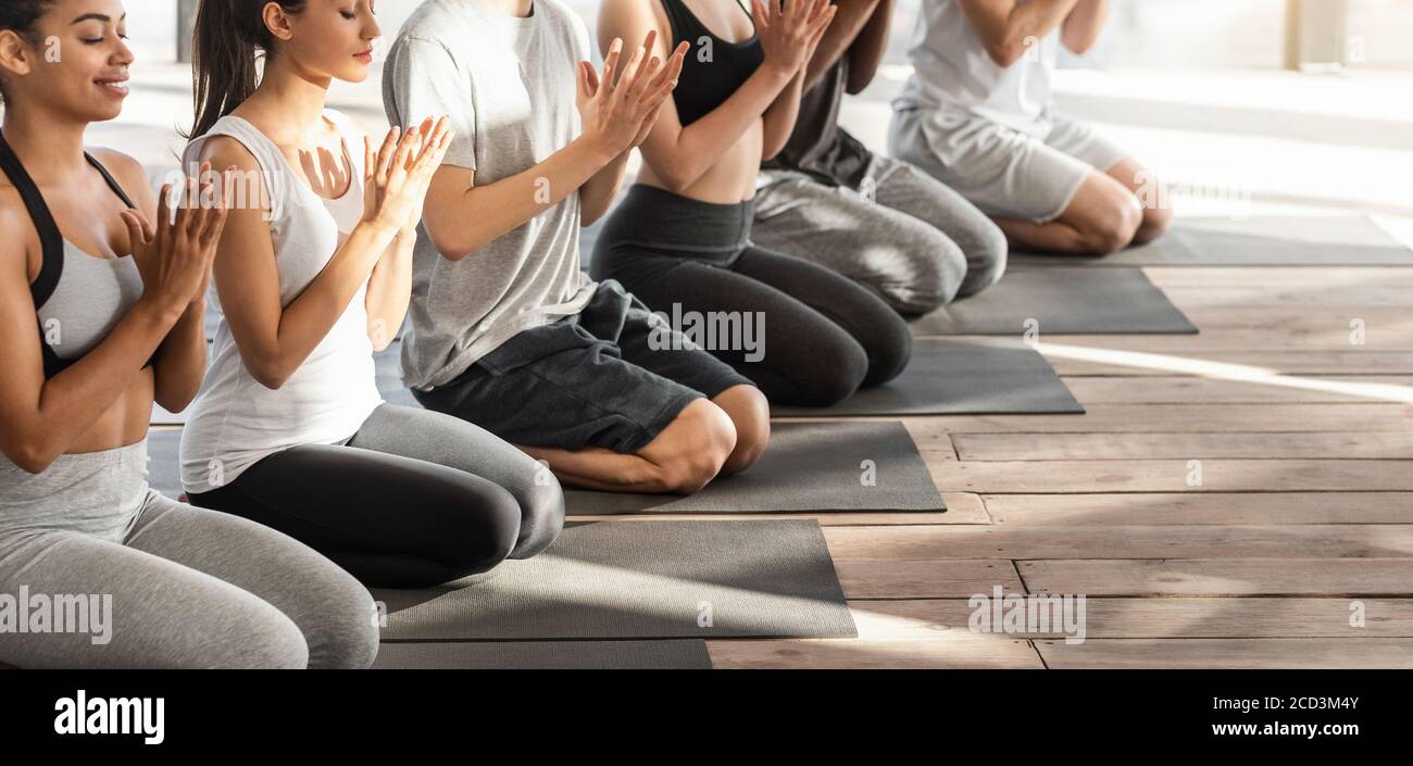 Junger Multiethnischer Yogi, Der Während Des Gruppentrainings Lotusrobben-Geste Macht In Studio Stockfoto