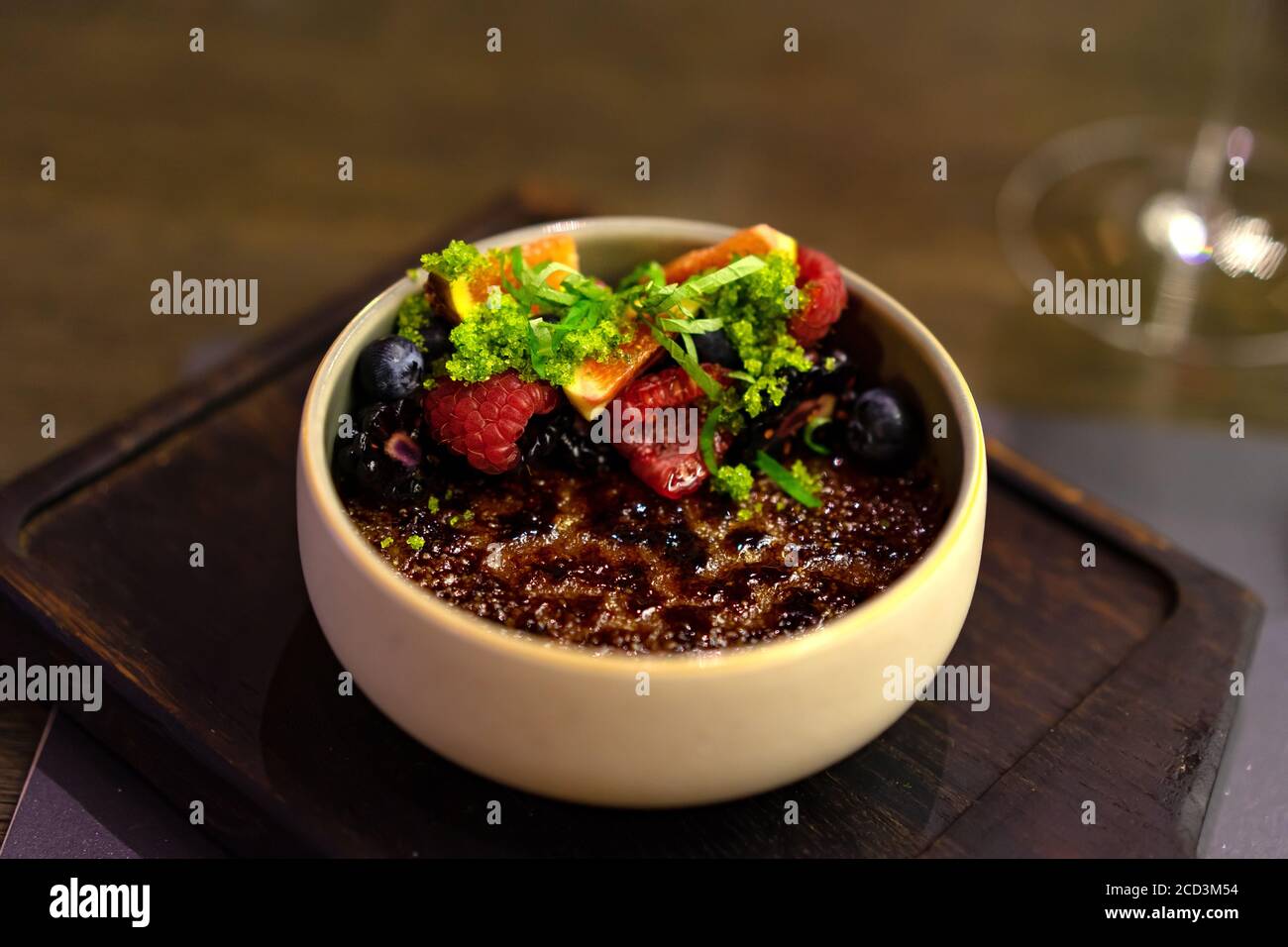 creme Brulee mit karamellisiertem Zucker Pudding mit Beeren und verziert Minze Stockfoto