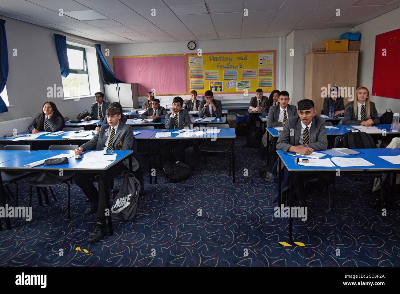 Schüler der 7. Und 11. Jahre kehren zur Manor High School in Oadby, Leicestershire, zurück. Derzeit hat die Schule eine freiwillige Politik in Bezug auf Schüler, die Gesichtsbezüge tragen, eingeführt. Stockfoto
