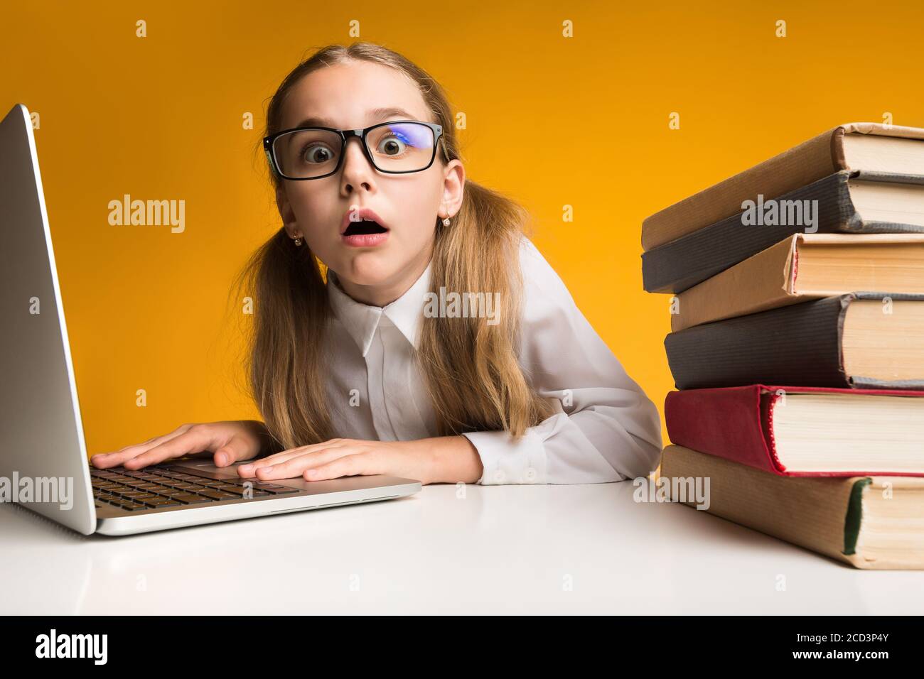 Überwältigt Schulmädchen Am Laptop Tun Online Hausarbeit Über Gelben Hintergrund Stockfoto
