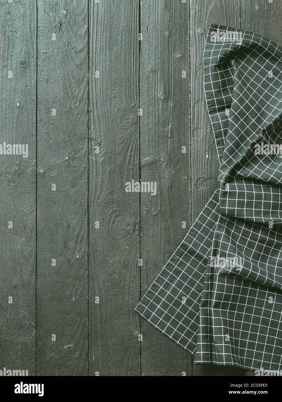 Dunkler Holztisch mit Balck und weißem dunklen Leinen Küchentuch oder Textil Serviette flach legen. Dunkle Tischdecke auf braun-grauem Holztisch. Platz für Text kopieren. Kann als Modell für Design verwendet werden. Vertikal. Stockfoto