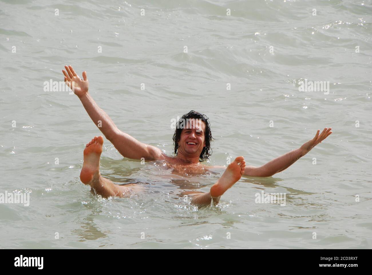 Israel, das Tote Meer, der Mensch schwimmt im schweren Salzwasser des Sees Stockfoto