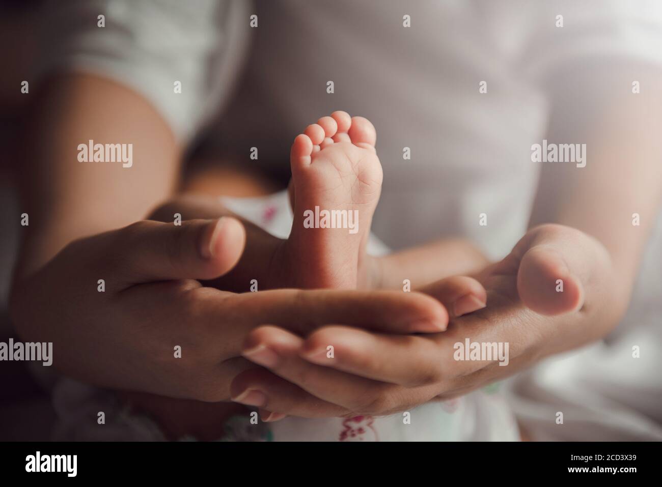 Übergeordnete Holding in den Händen Füße der neugeborenen Babys. Stockfoto